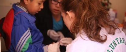 An intern works with a young patient on Projects Abroad's Medical internship for teenagers in Peru A high school student takes a child's blood sugar measure on our medical internship in Peru